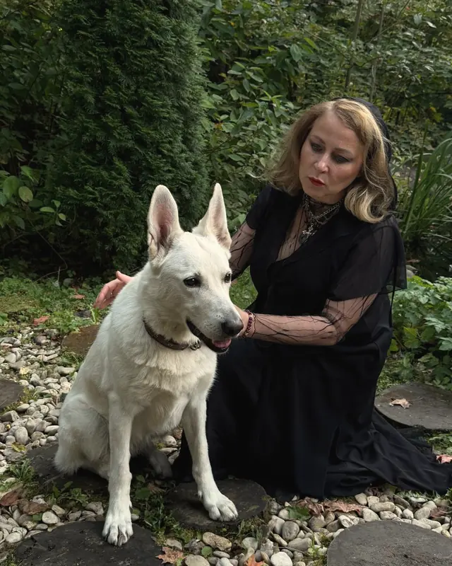 Alice in the garden with a white shepherd dog